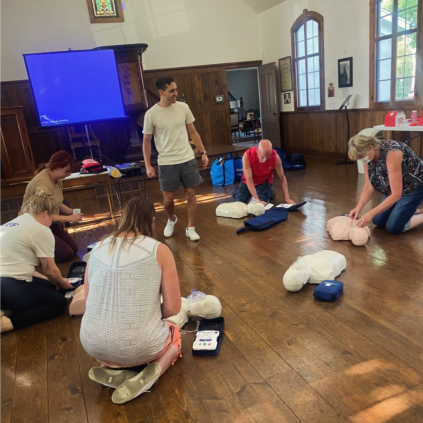 Group of people practicing CPR training with instructor